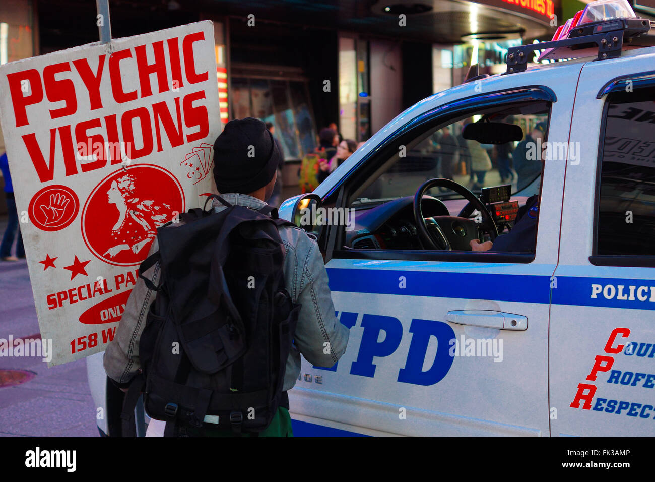 Man holding 'Psychic Visions' signs talks to the police Stock Photo