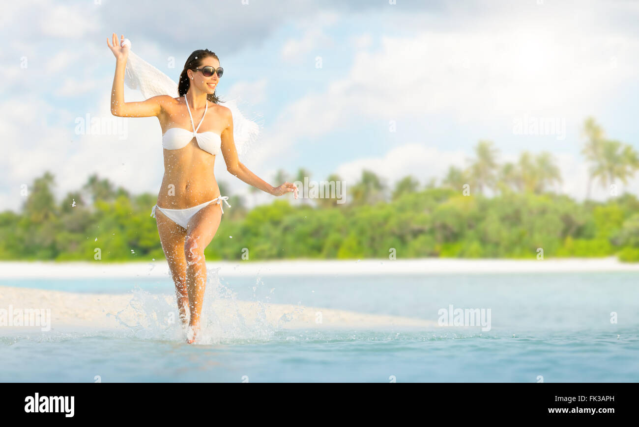 Beautiful girl running on tropical beach Stock Photo