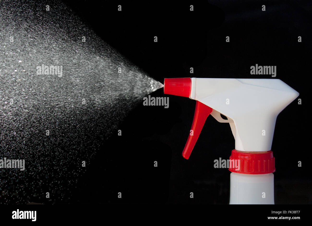 Spray from a bottle of cleaner on a black background Stock Photo - Alamy