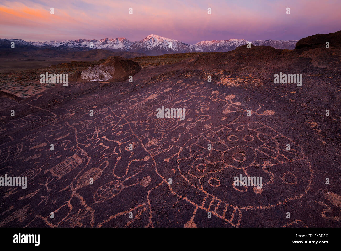 Sunrise at Sky Rock petroglyphs near Bishop in the Owens Valley area of California with the High Sierra in the background. These Stock Photo