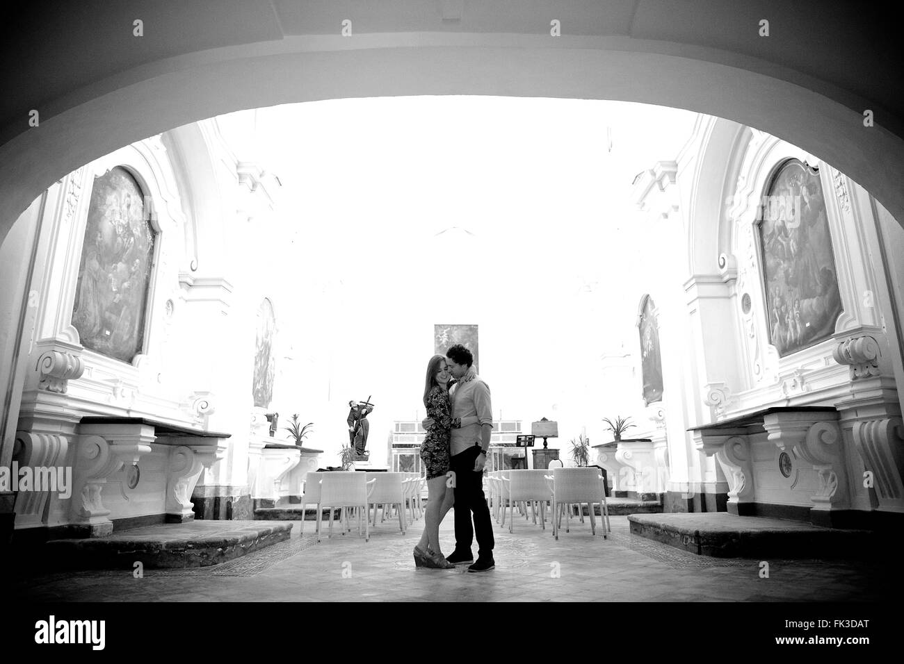 A young and in love couple in an old intimate Italian chapel, they contemplate their future, marriage - Amalfi town, Coast, Stock Photo