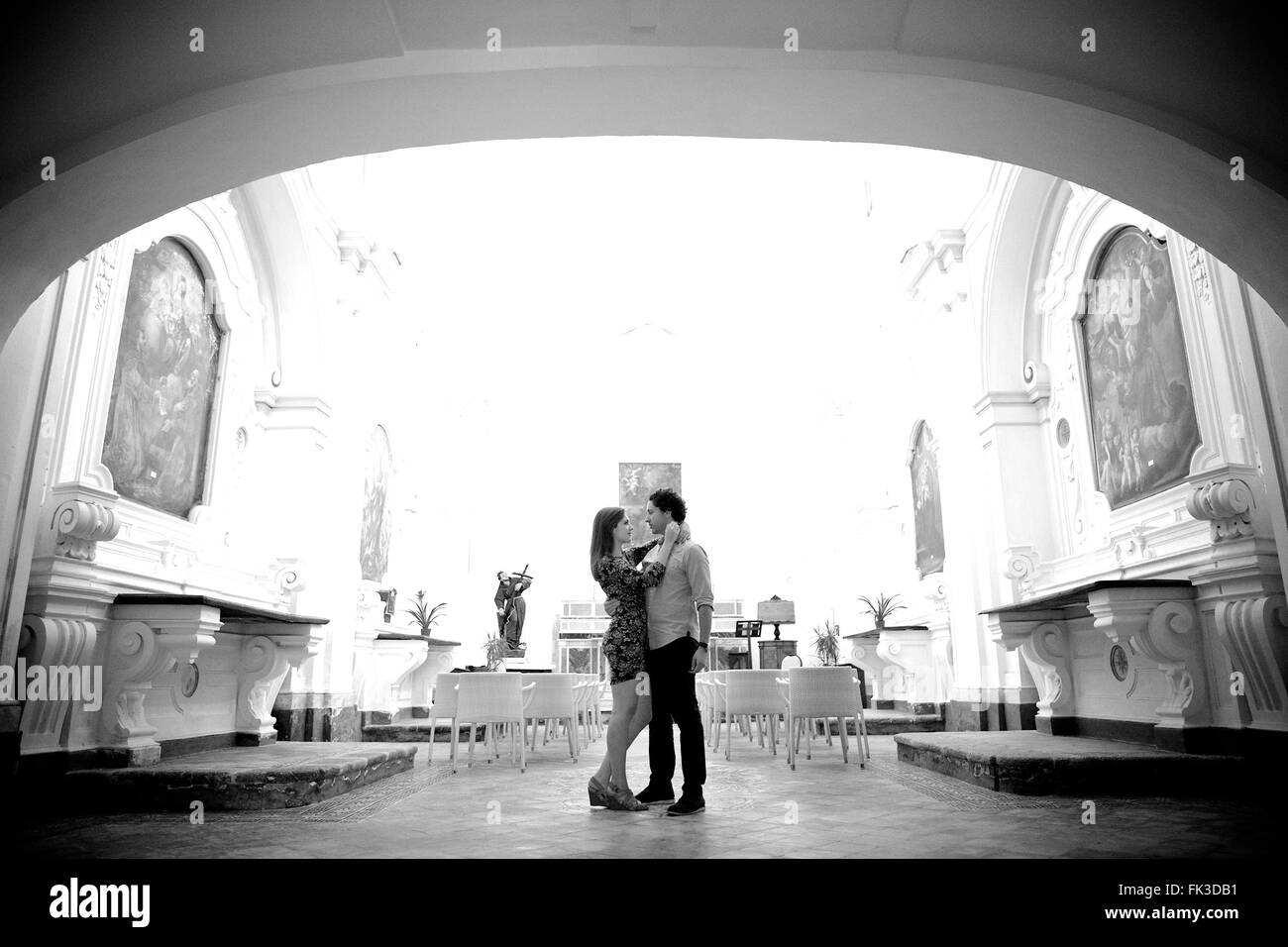 A young and in love couple in an old intimate Italian chapel, they contemplate their future, marriage - Amalfi town, Coast, Stock Photo