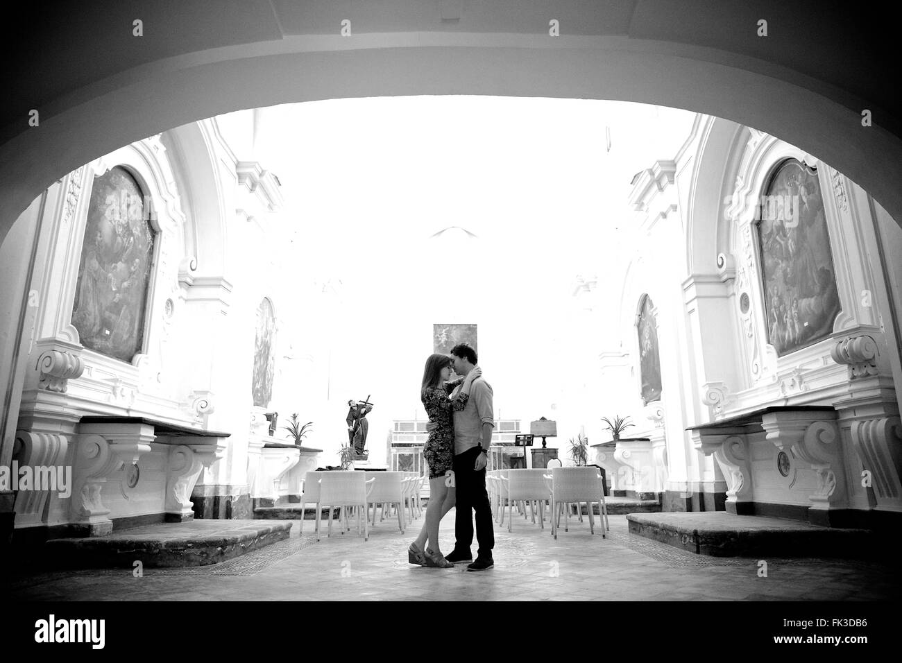 A young and in love couple in an old intimate Italian chapel, they contemplate their future, marriage - Amalfi town, Coast, Stock Photo
