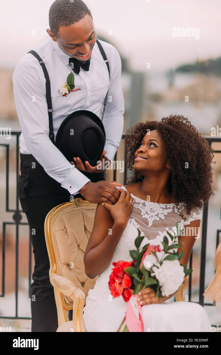 Exotic african bride and groom holding hands on the terrace Stock Photo