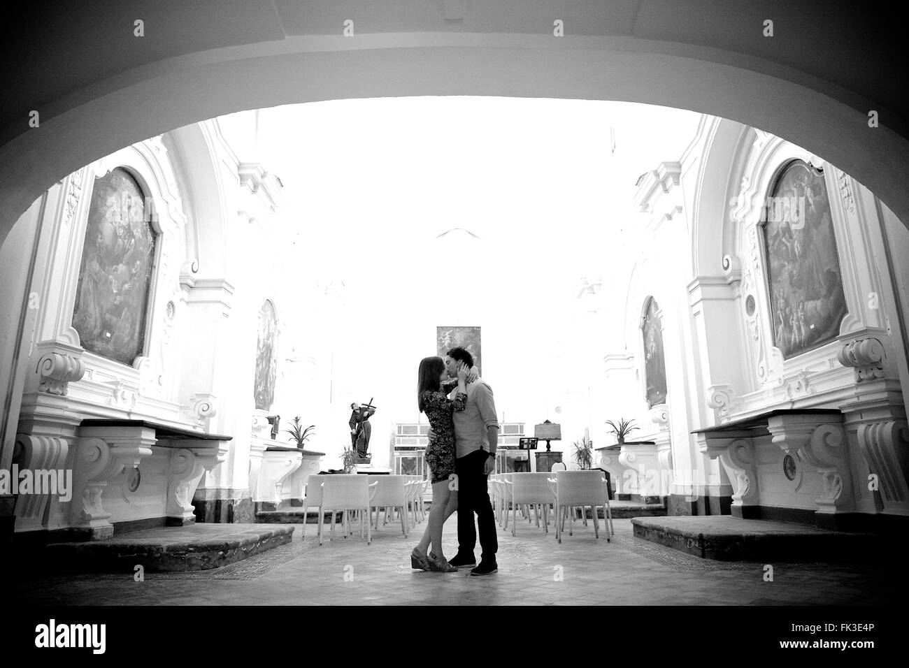 A young and in love couple in an old intimate Italian chapel, they contemplate their future, marriage - Amalfi town, Coast, Stock Photo
