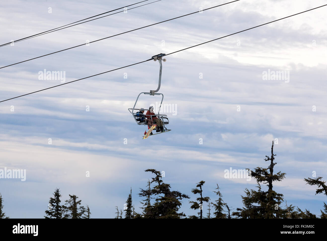 Snowboarders riding Ski Lifts up the slope of Mount Hood in Winter Season Stock Photo