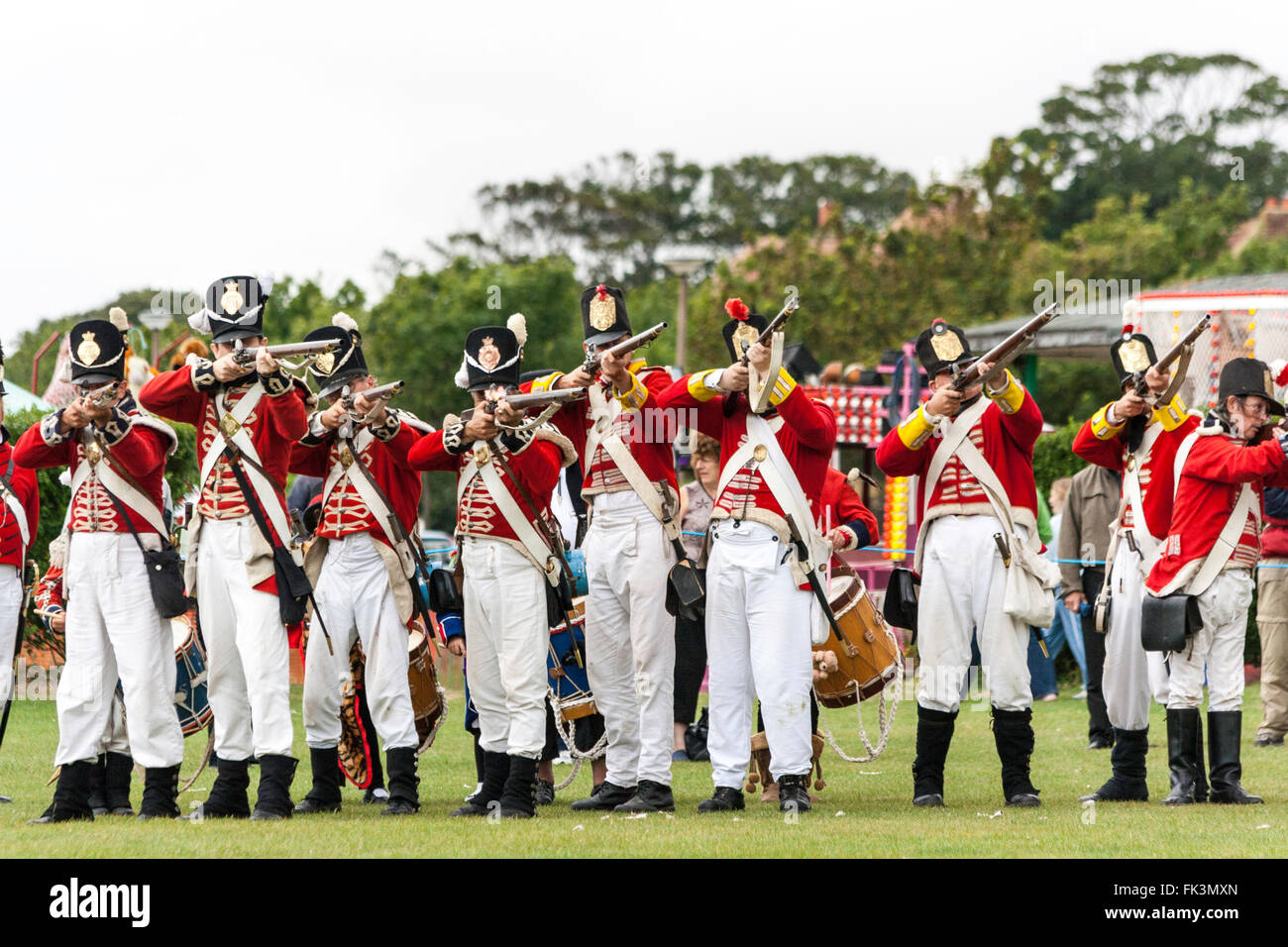 Napoleonic war re-enactment, living history. English Redcoats, 1st foot regiment, lined up taking aim during battle re-construction. Stock Photo