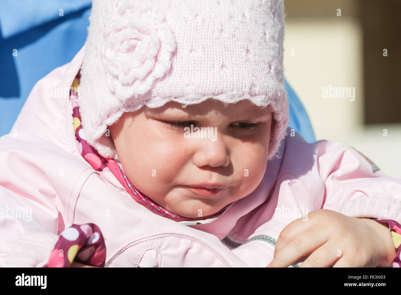 Little baby girl in pink crying, closeup outdoor portrait Stock Photo