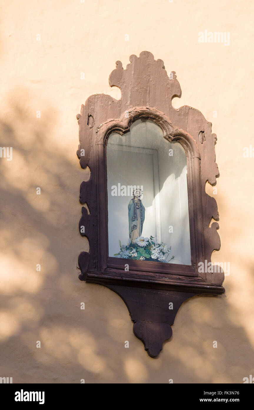 Decorative niche in the wall with religious sculpture, sunlight and shadows Stock Photo