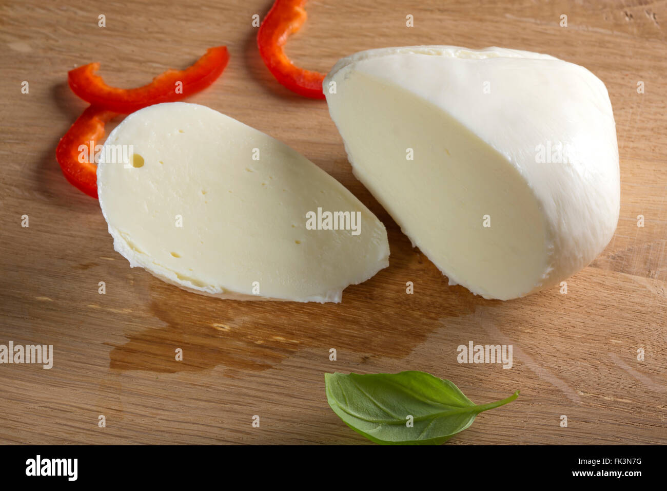 Buffalo mozzarella on wooden table with red pepper. Selective focus. Stock Photo