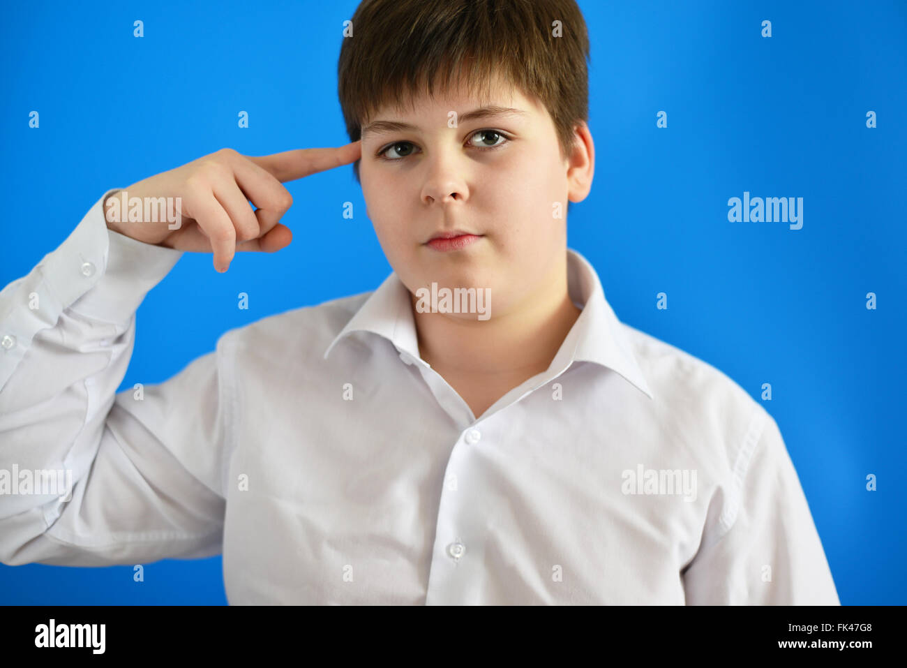 Pensive teenage boy on  blue background Stock Photo