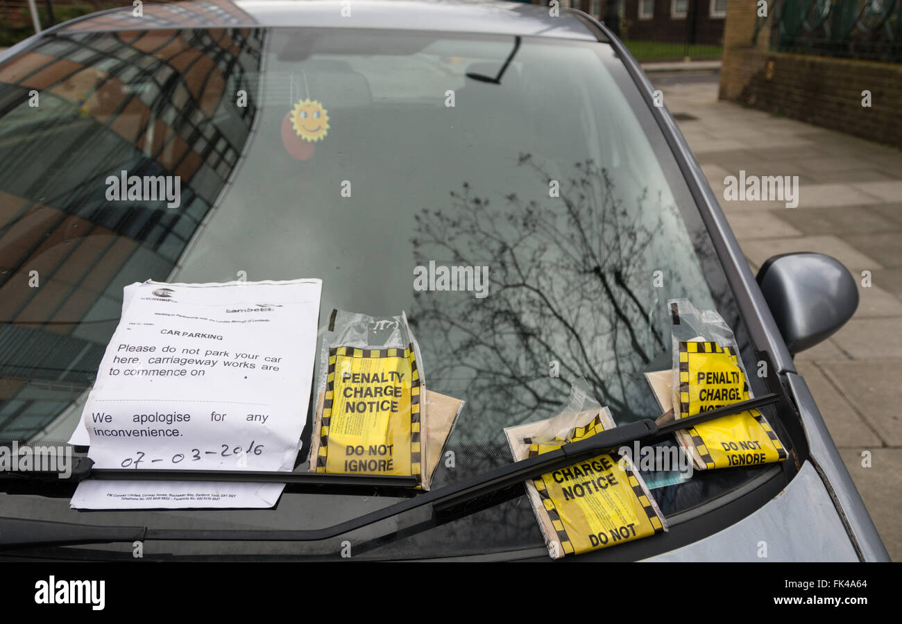 Three yellow penalty charge notice tickets on a car windscreen in London, England, UK Stock Photo