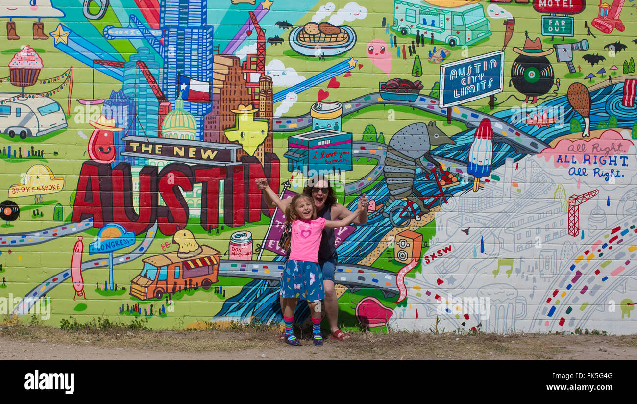 A woman ans her niece pose for a photo by a mural in Austin Stock Photo