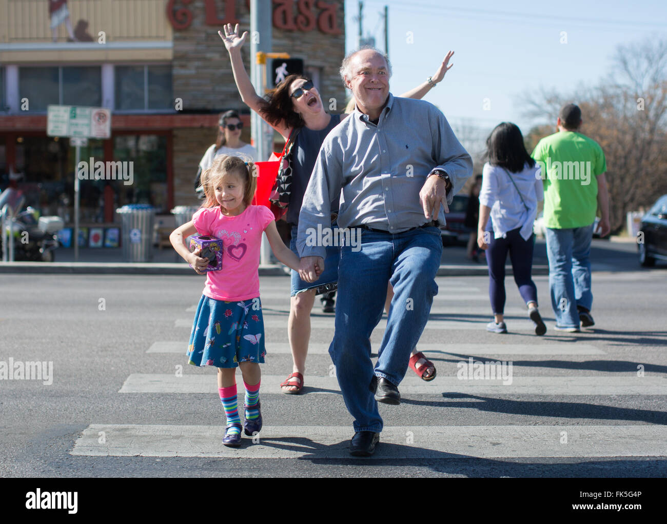 A family clown around while crossing South Congress Street in Austin, Texas Stock Photo