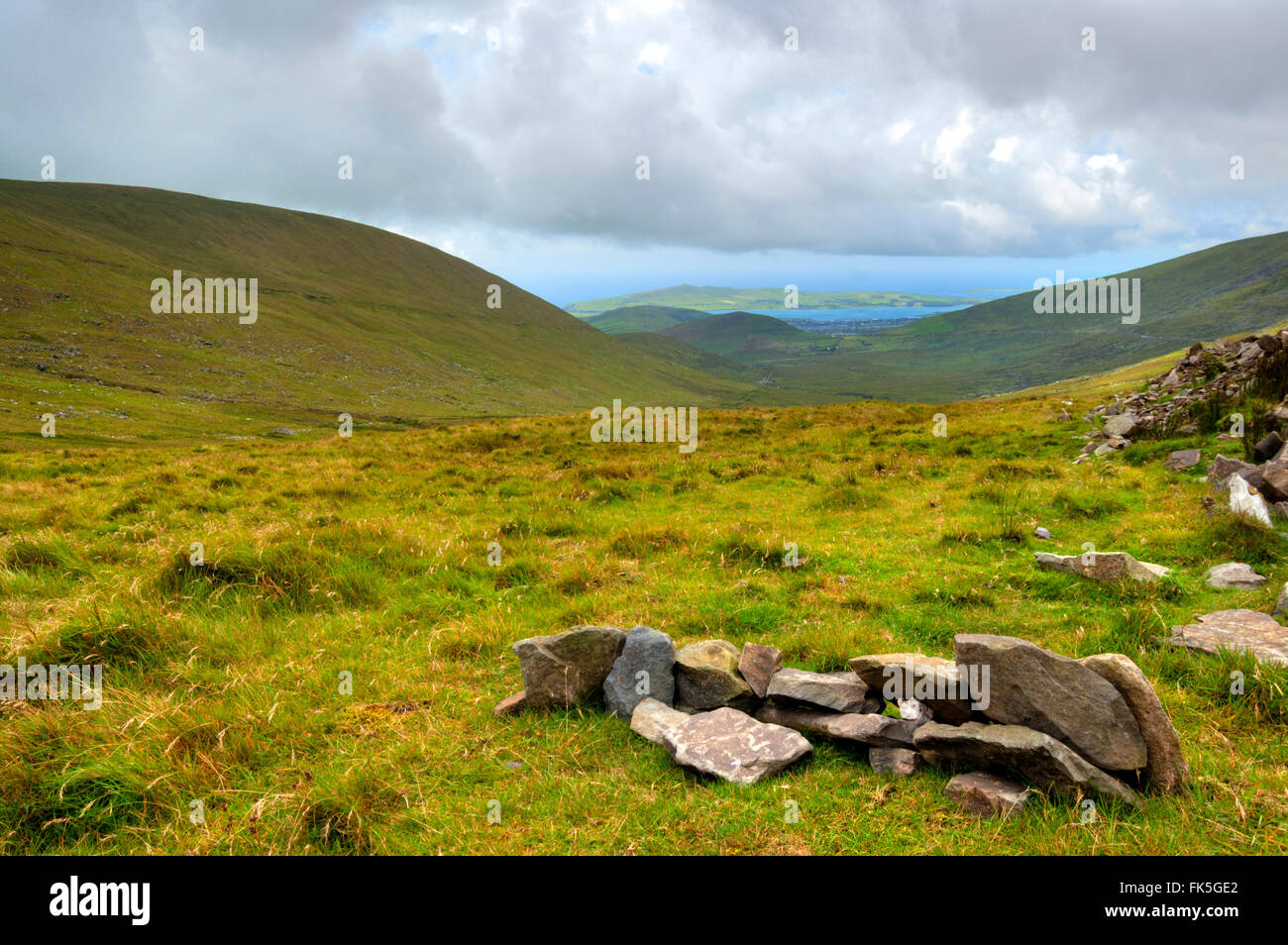 Green valleys with hills and lakes with moody sky over Ring of Kerry in County Kerry, Ireland Stock Photo