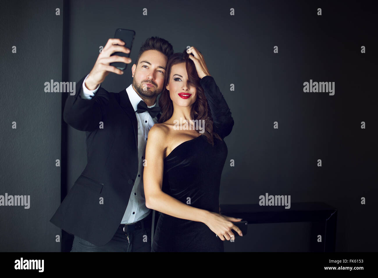 Fashionable rich celebrity couple taking selfie indoor Stock Photo