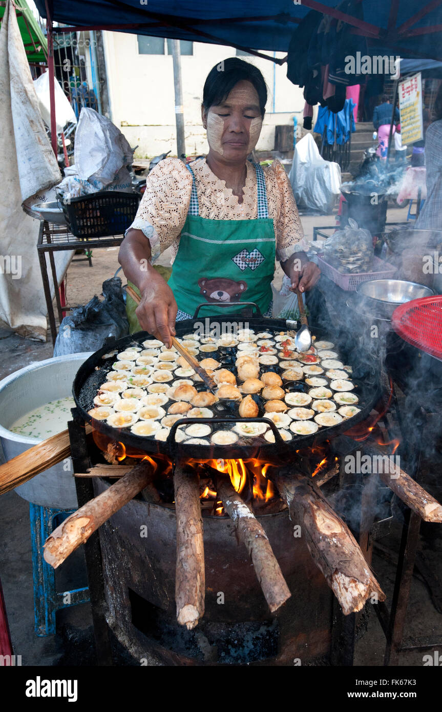 Woman frying tiny chickpea and quails egg fritters on a street market food stall in Pyin Oo Lwyn, Mandalay Division, Myanmar Stock Photo
