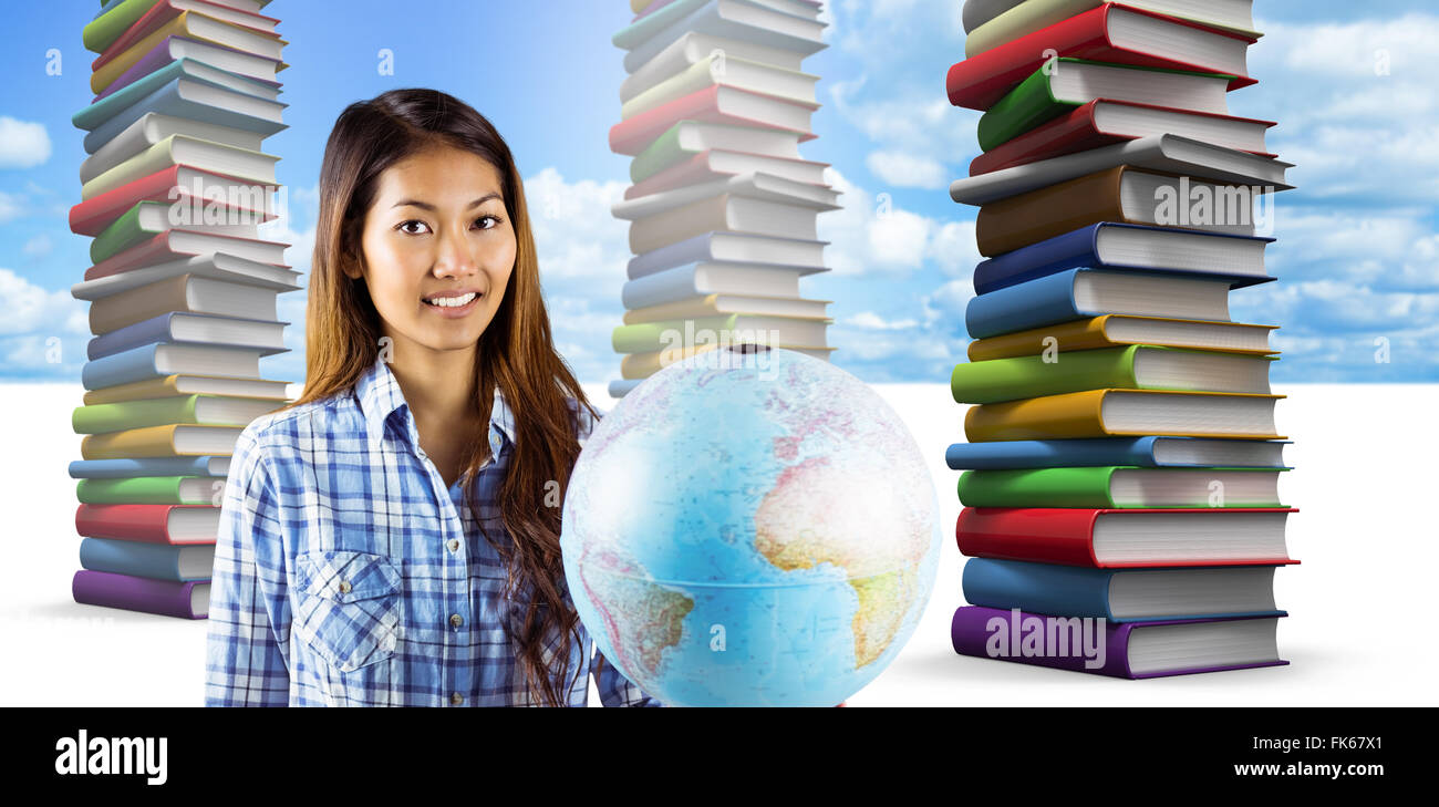 Composite image of smiling asian woman holding a globe Stock Photo - Alamy