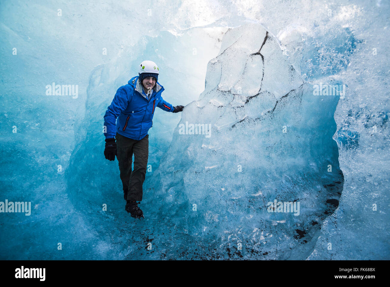 Tourist exploring an ice cave on Breidamerkurjokull Glacier, Vatnajokull Ice Cap, Iceland, Polar Regions Stock Photo