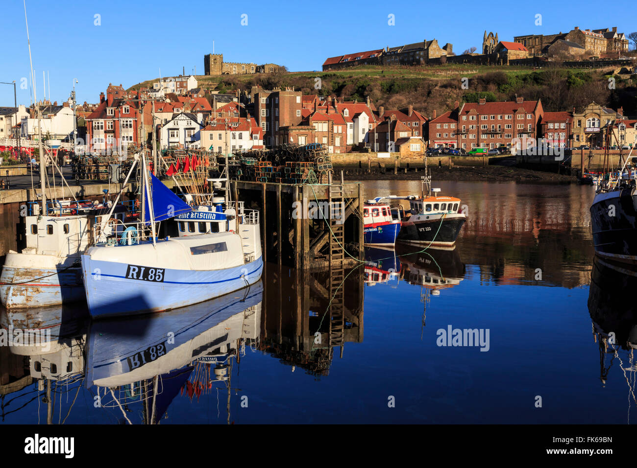 St. Mary's Church and reflections at Endeavour Wharf with lobster pots and boats, Upper Harbour, Whitby, North Yorkshire Stock Photo