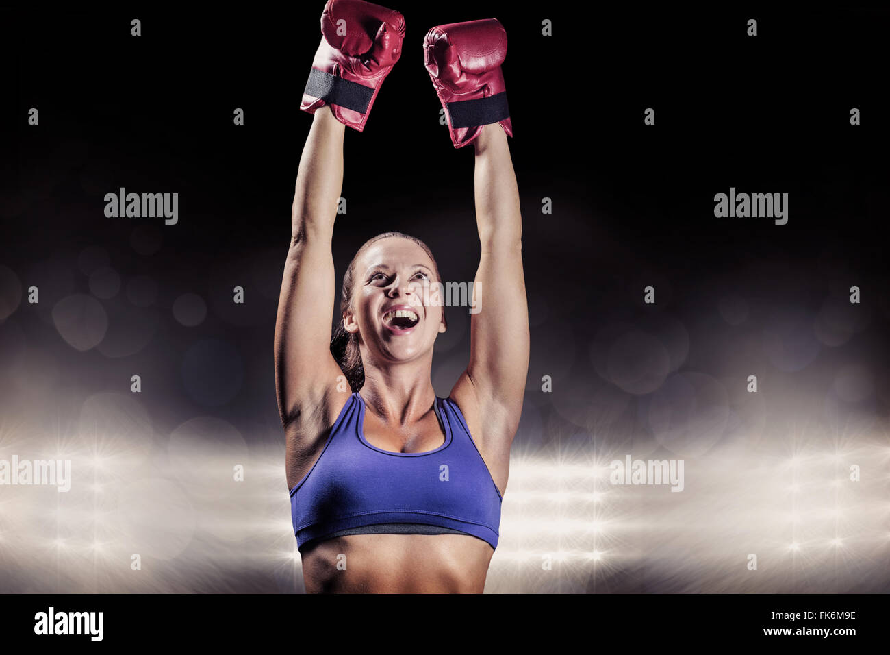 Composite image of winning fighter with arms raised Stock Photo