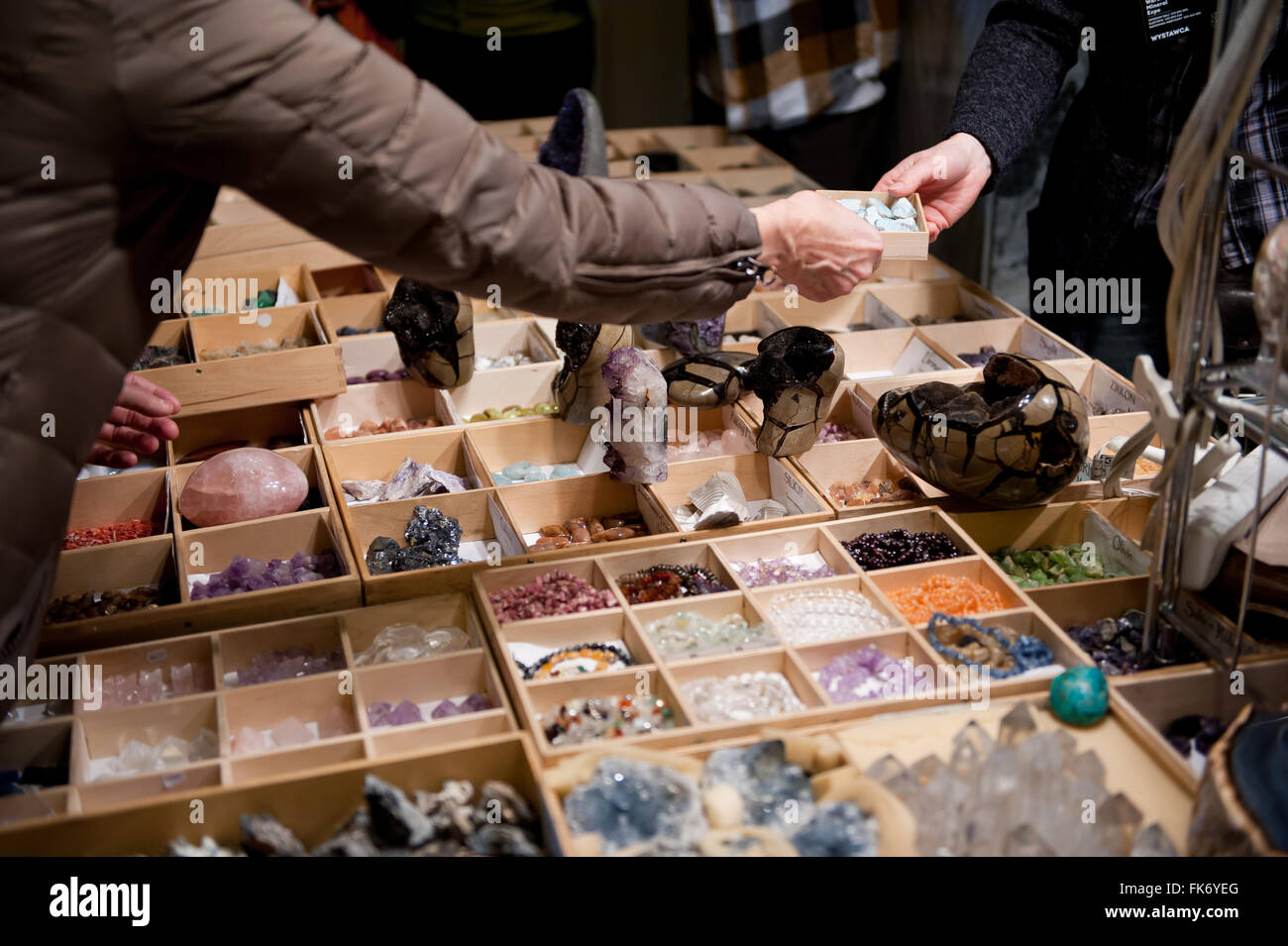 Women buying gemstones, beads lying in boxes, stand at the Warsaw