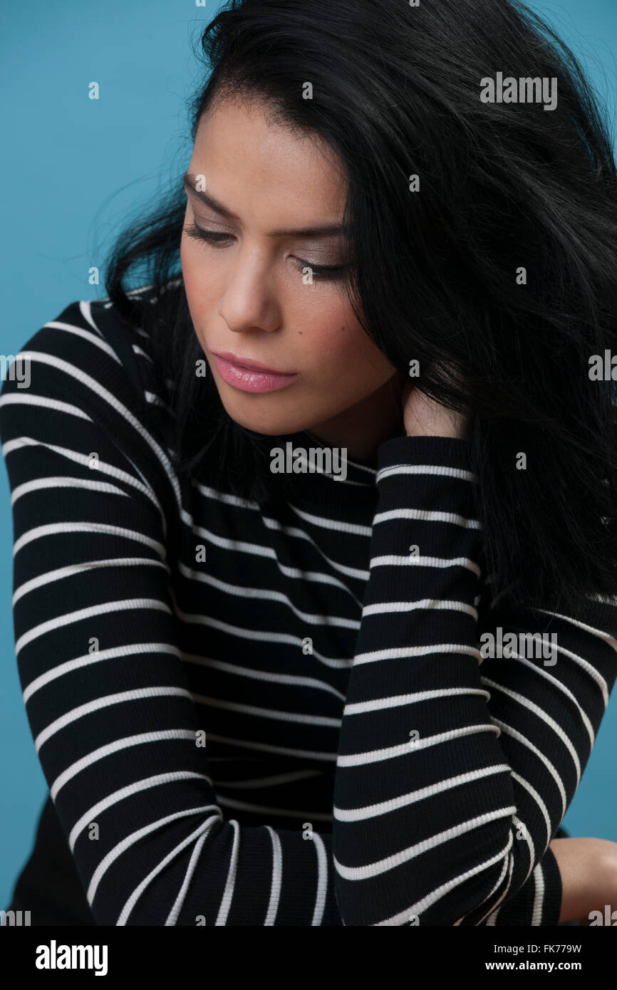 Female model with black hair deep in thought Stock Photo