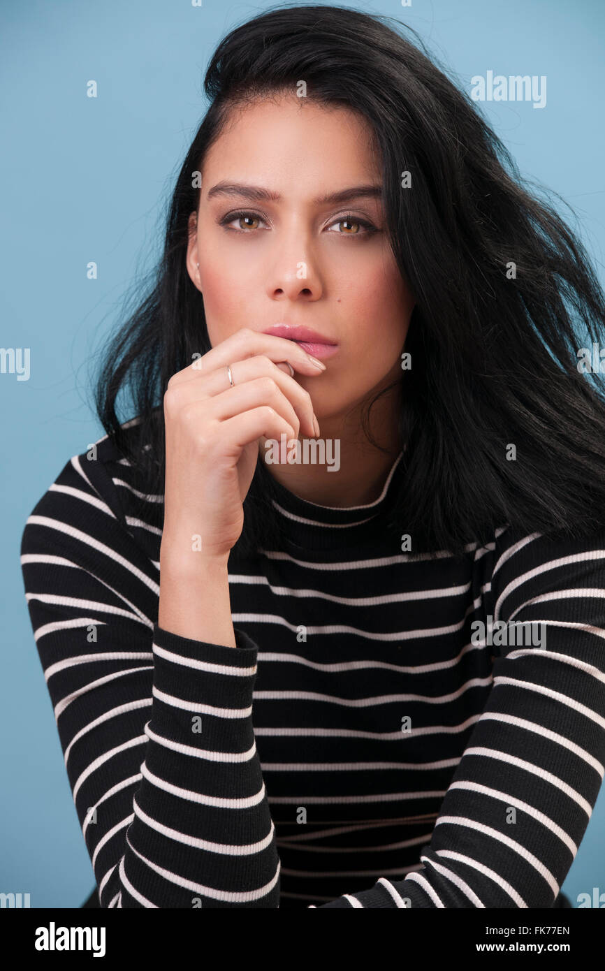 Female model with black hair deep in thought Stock Photo