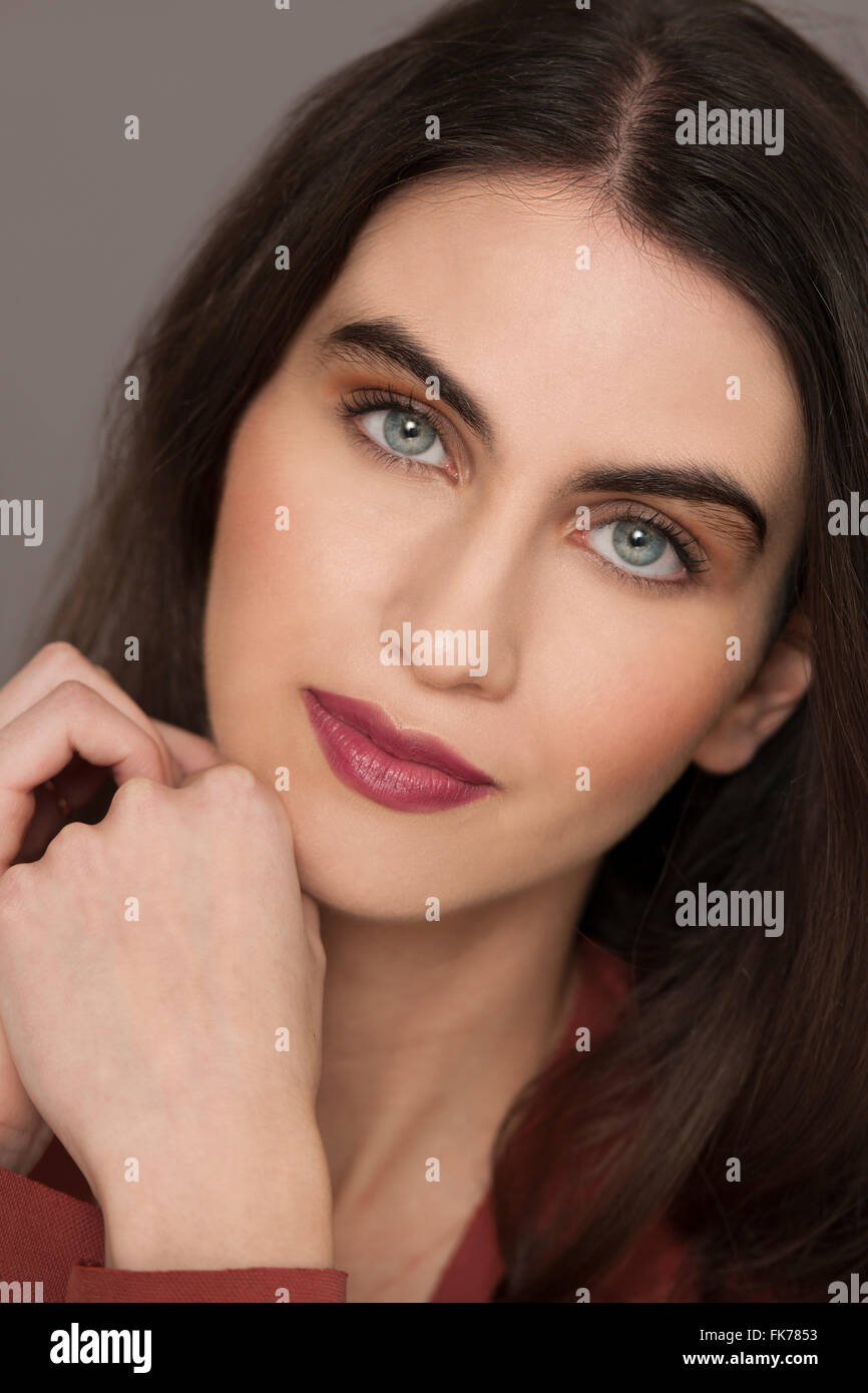 Close up of a dark haired model wearing make up in the studio Stock
