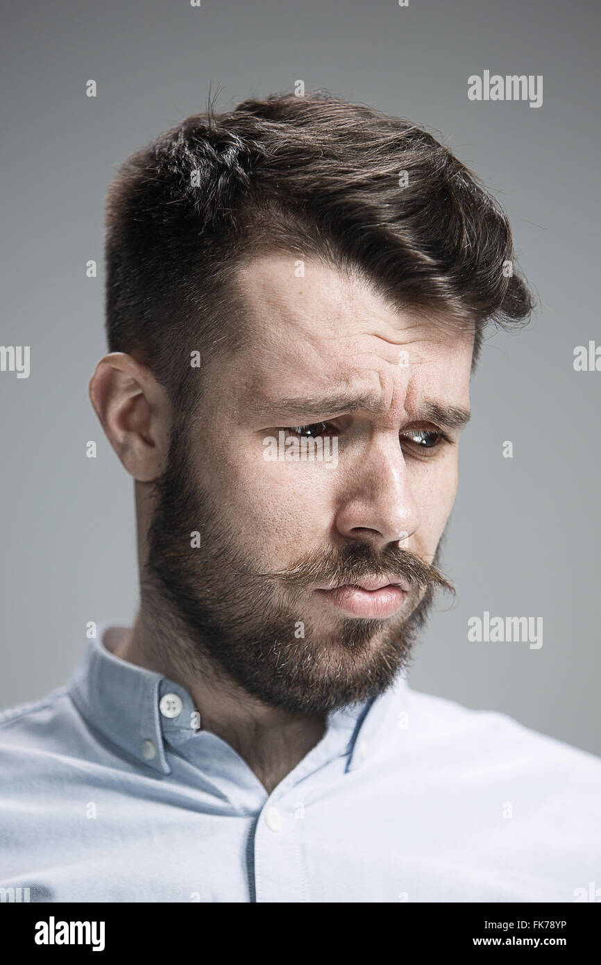Close up of face of discouraged man on gray background Stock Photo - Alamy