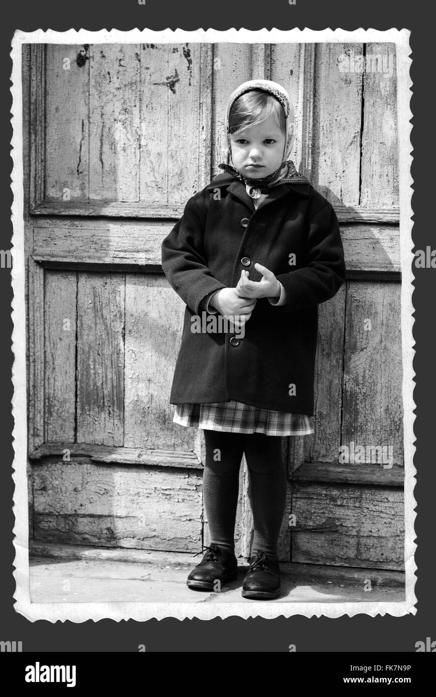 Photo in retro style. Cute little girl in a kerchief. Selective focus. Stock Photo