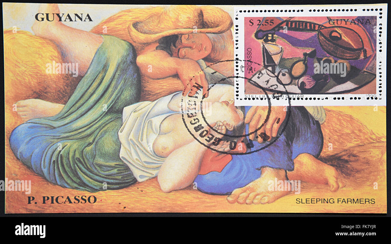 GRANADA, SPAIN - DECEMBER 1, 2015: Stamp printed in Guyana shows still life with guitar and sleeping farmers by Picasso, 1990 Stock Photo