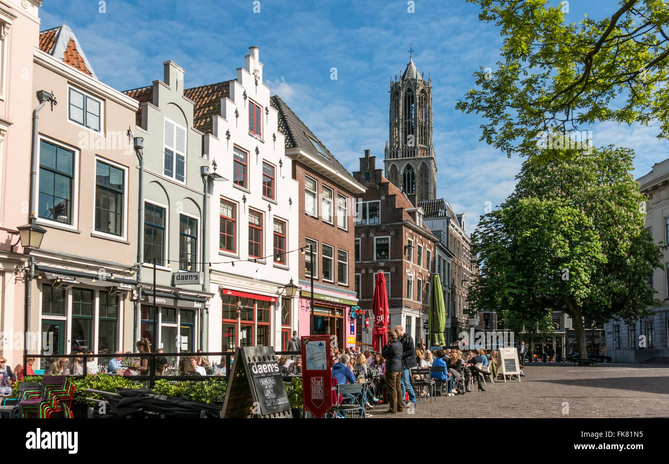 Cafes and facades of old houses on Minrebroederstraat and the tower of Dom Church in the city of Utrecht, Netherlands Stock Photo