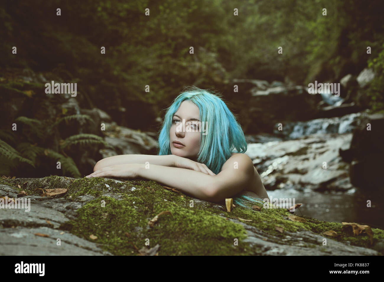 Young forest woman with innocent expression in a dark stream . Myth and fantasy Stock Photo