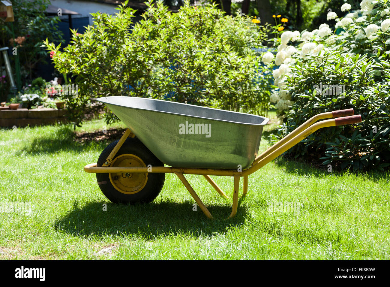 Wheelbarrow in garden Stock Photo Alamy