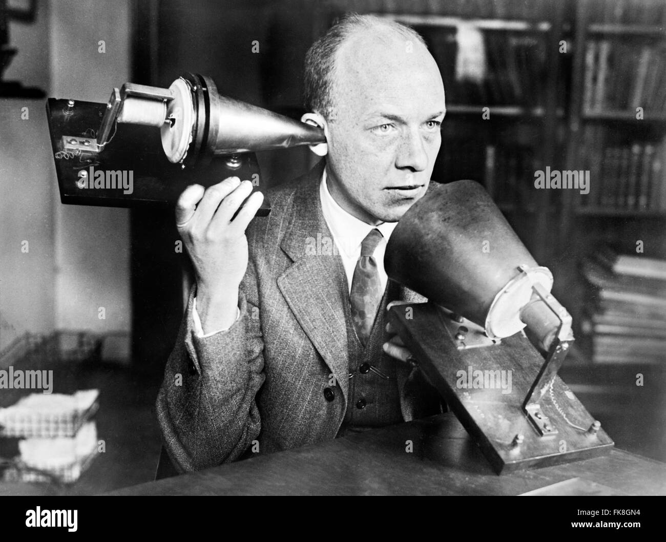 A man using Alexander Graham Bell's first telephone, published in the Detroit News between 1915 and 1925. Stock Photo