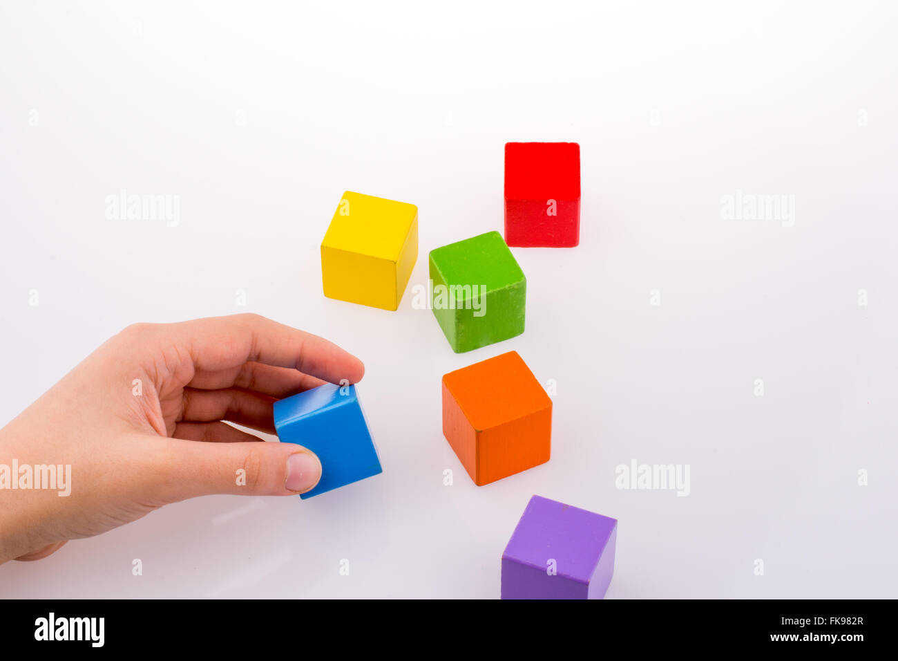 Hand playing with colorful cubes on a white background Stock Photo - Alamy