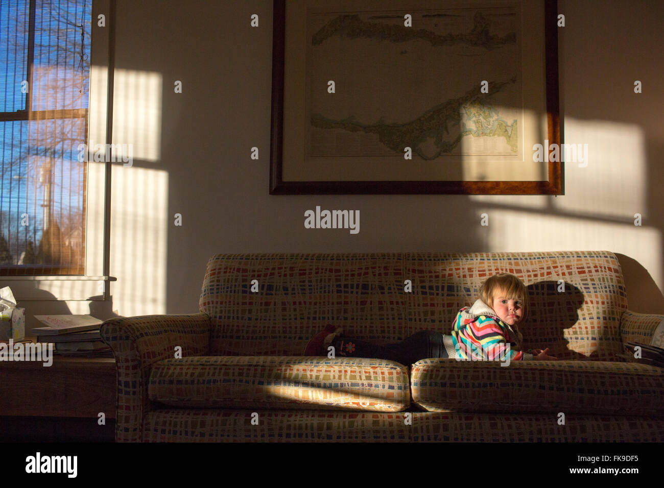 Toddler playing on the coach in the afternoon light Stock Photo Alamy