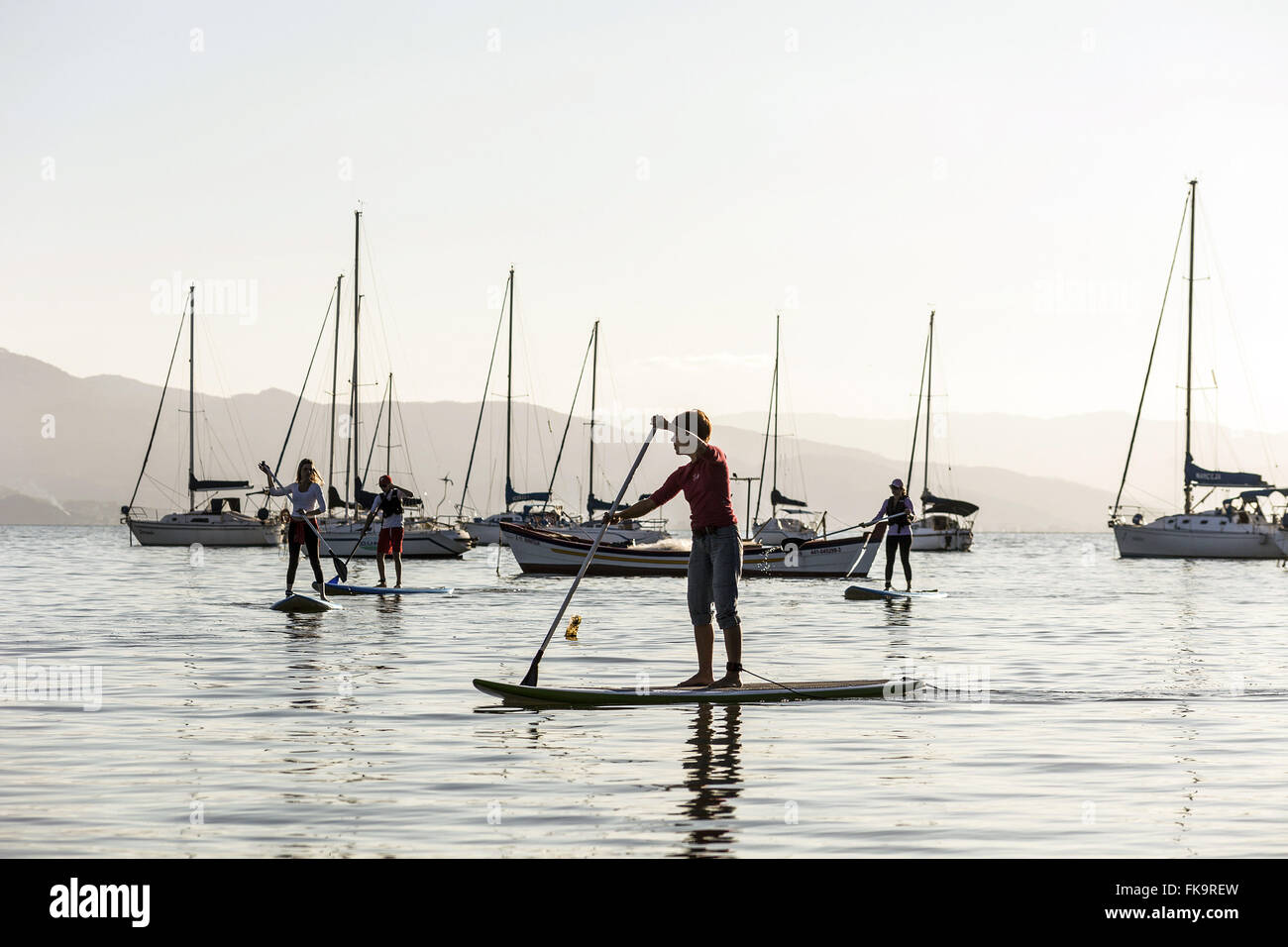 Stand up paddle in Santo Antonio de Lisboa beach with sailboats anchored to the bottom Stock Photo