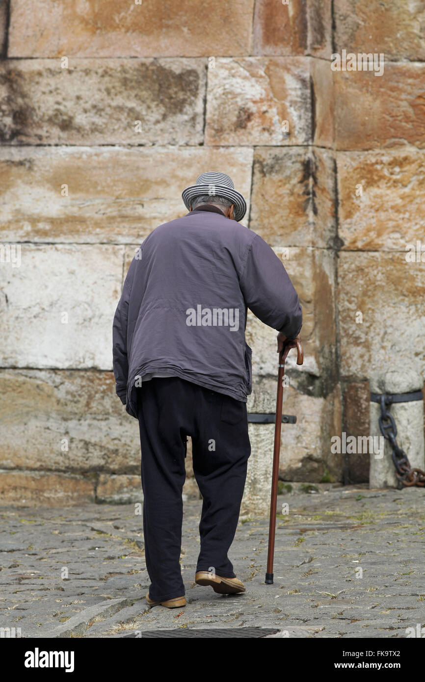 Person walking in the city center with the aid of a cane Stock Photo