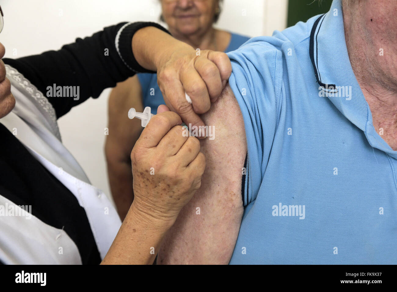 Idoso sendo vacinado contra a Gripe Influenza em posto de saúde Stock Photo