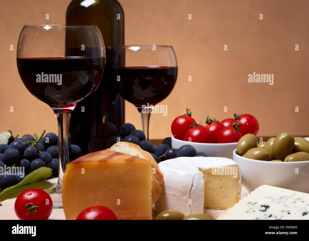 Still life with cherry tomato, red wine and cheese Stock Photo - Alamy
