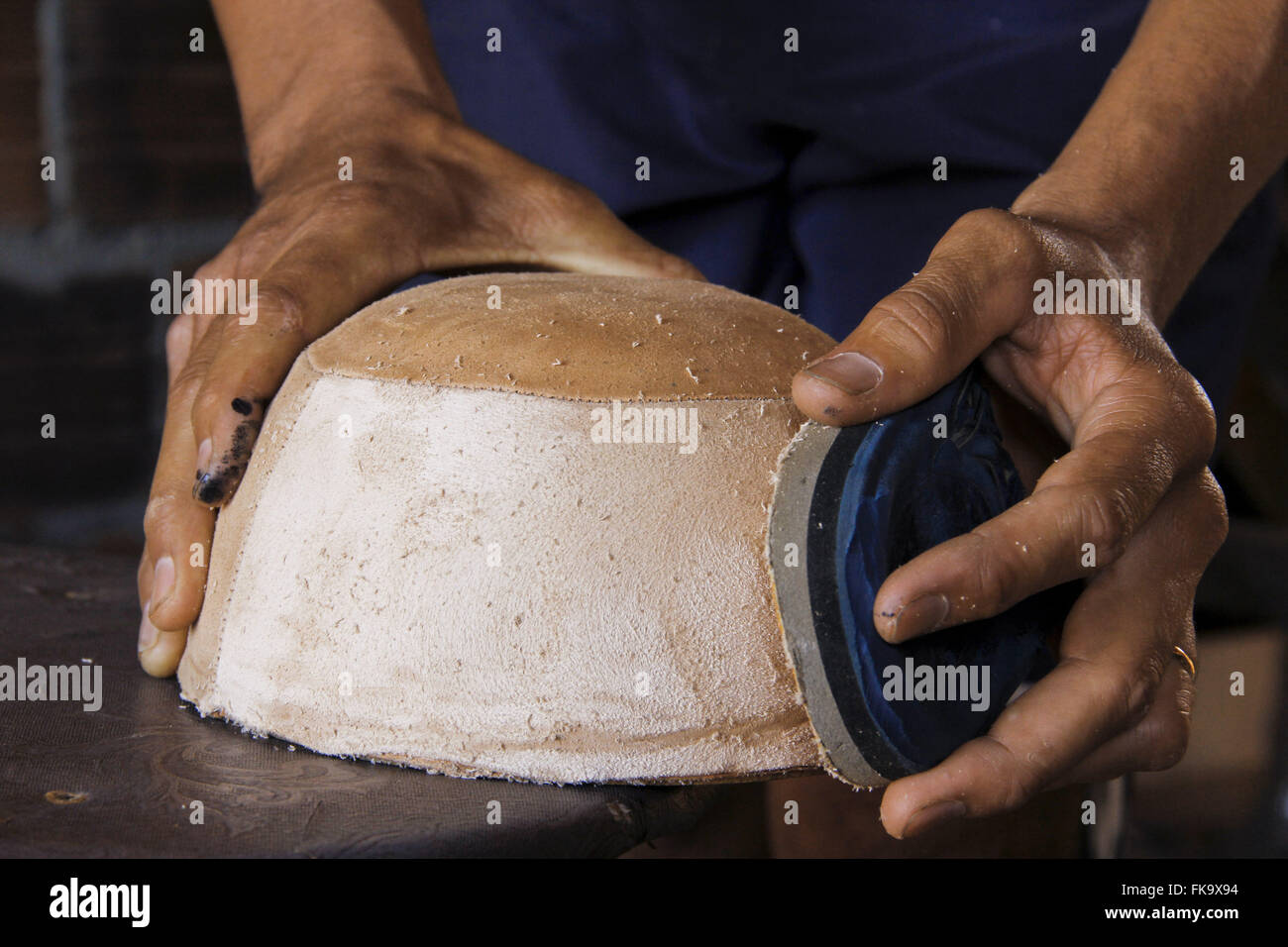 Autonomous worker sanding mold manufactures handmade hats in the village of Alegre Stock Photo