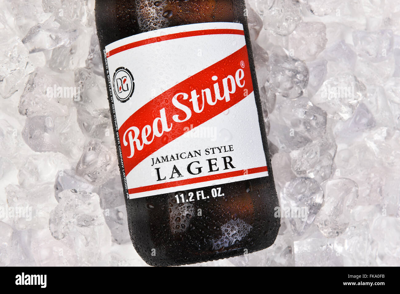 A bottle of Red Stripe Jamaican Lager on a bed of ice. Horizontal format. Stock Photo