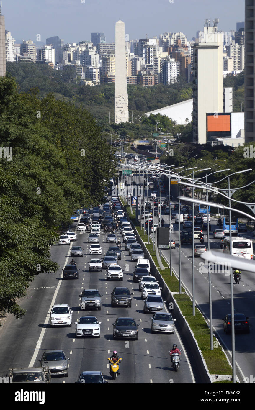 Trânsito de veículos na Avenida 23 de Maio com Obelisco e Parque Ibirapuera ao fundo Stock Photo