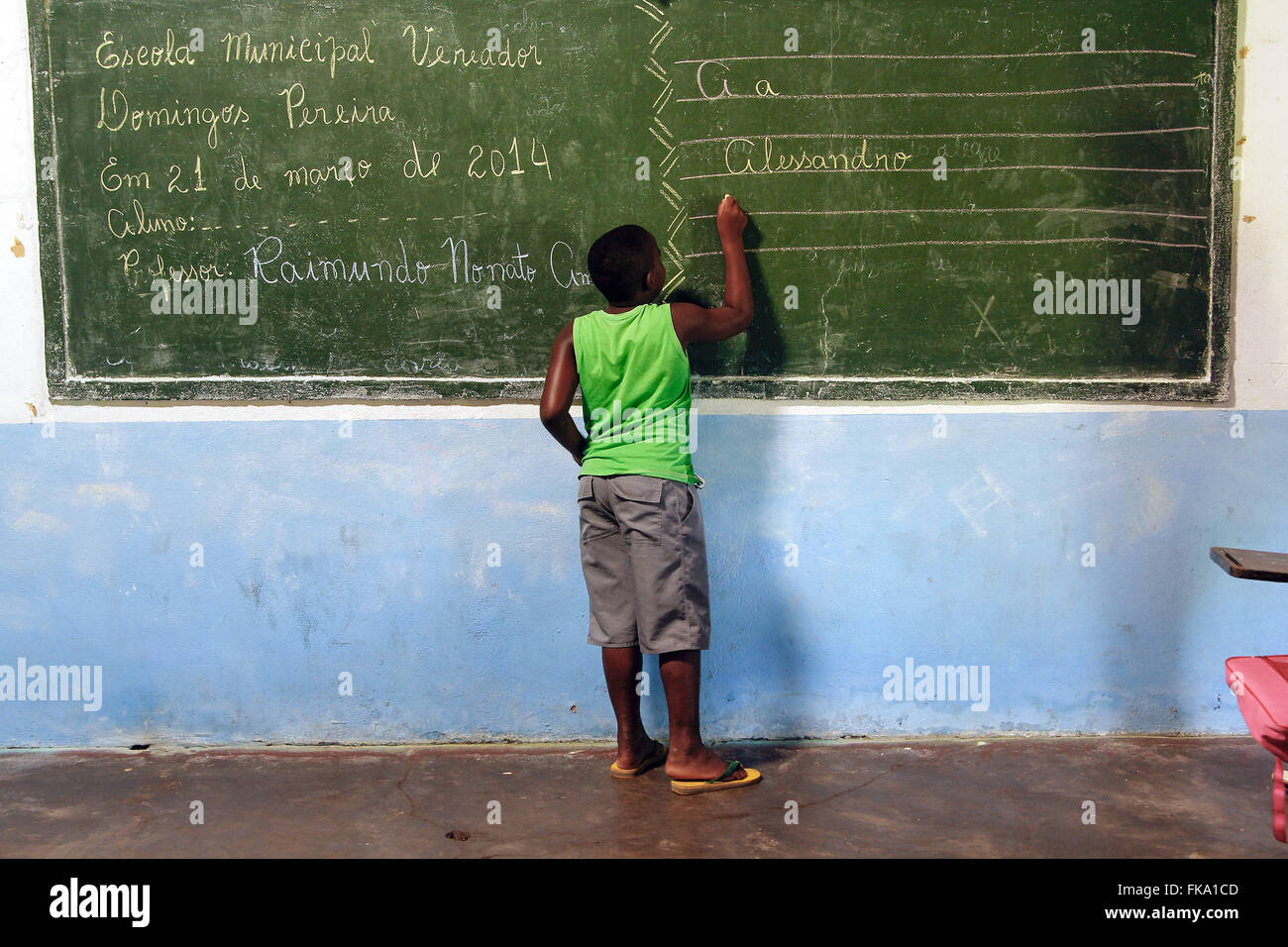 Student writing on the blackboard in the classroom of Escola Municipal Councilman Manuel Domingos Pereira Stock Photo