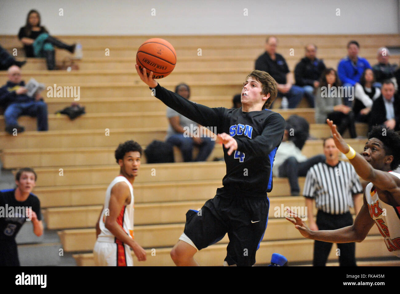 Open in the paint, a player under handing a shot while pursued by a ...