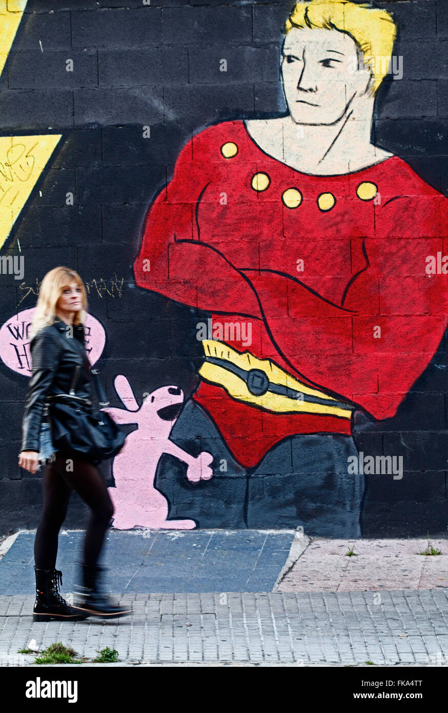 Woman passing in front a graffiti. Stock Photo