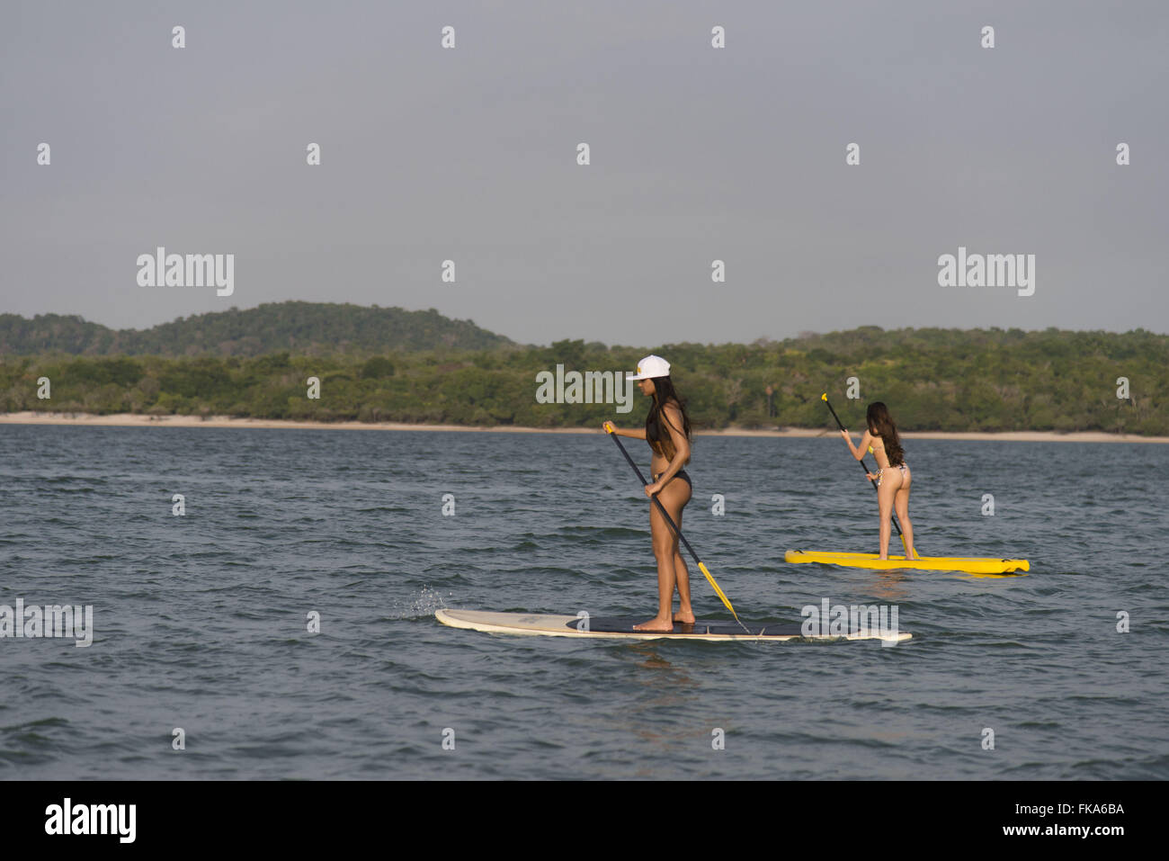 Teens practicing stand-up at the river beach of Alter-do-Chao in Rio Tapajos Stock Photo