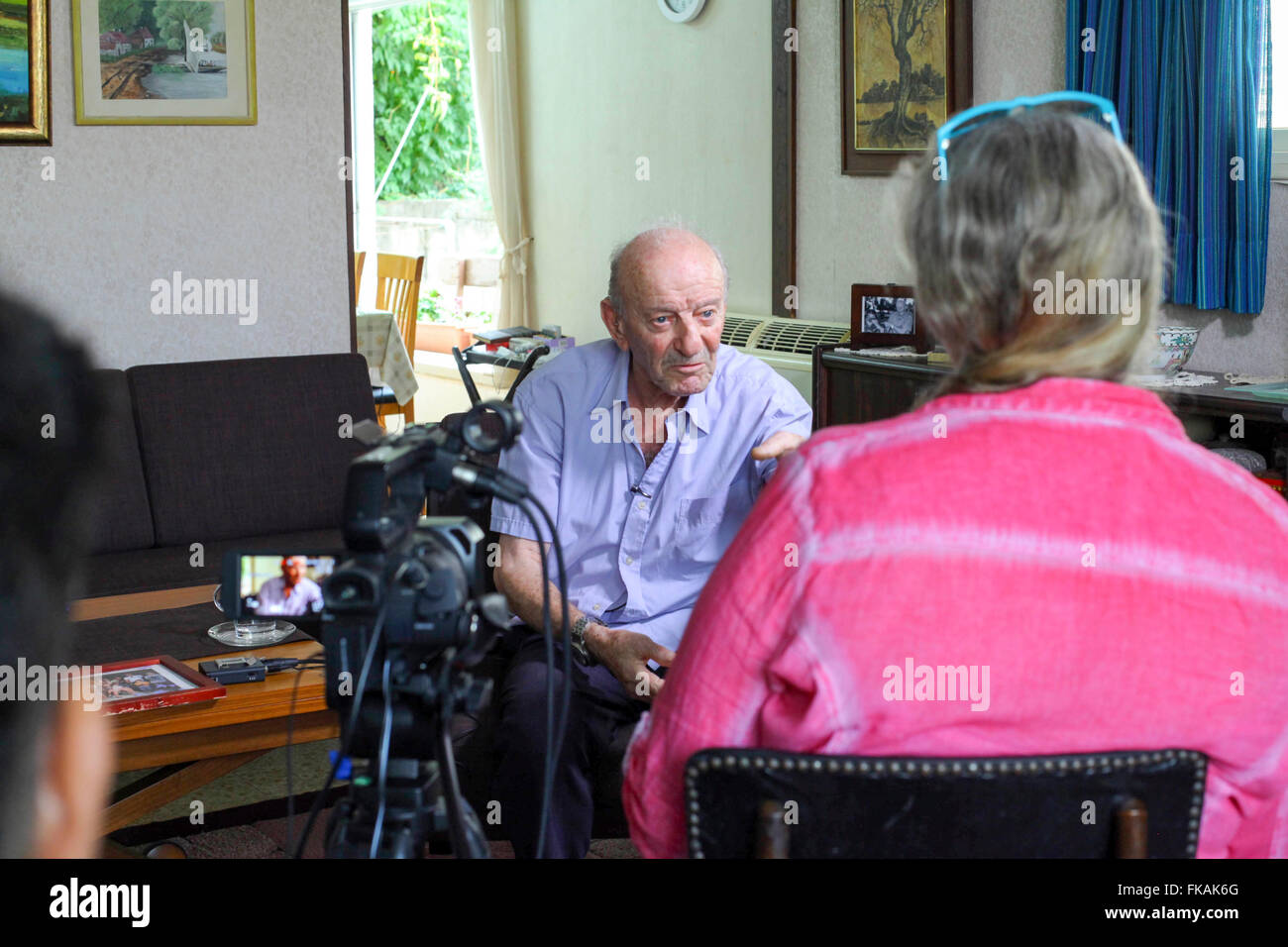 86 years old Avraham Avraham is being interviewed infront of a video camera by the Yad Vashem archive organization, giving testi Stock Photo
